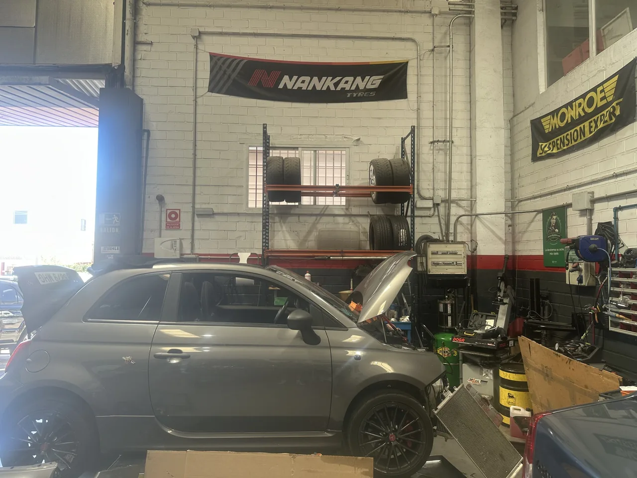 Abarth 595 con el capó abierto, en plena intervención