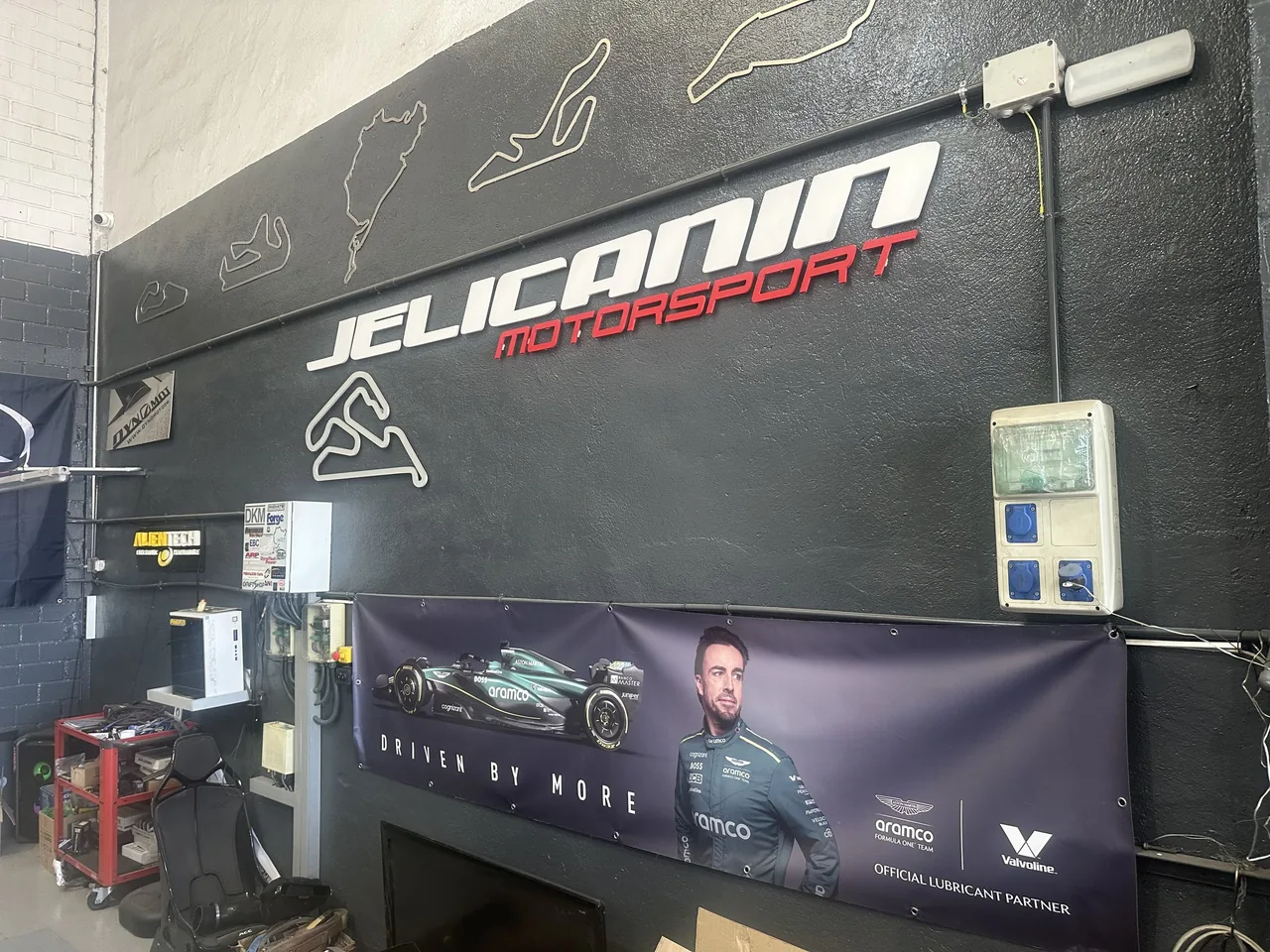 El rótulo del taller y los trazados de circuito en la pared